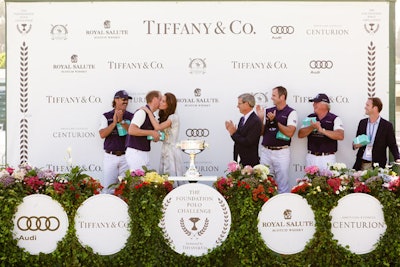 Prince William's team ultimately won, and he was awarded a trophy and a kiss from the duchess, in front of a press wall decorated in greenery, flowers, and logos.