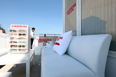White sofas and pillows with the Carrera logo faced tabletop displays of sunglasses in the shady portion of the venue's terrace.