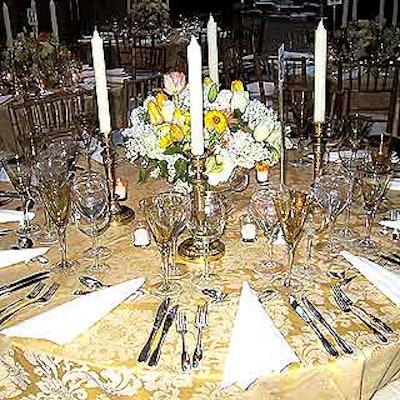 At each table, Isabell placed four white taper candles around tasteful flower arrangements.