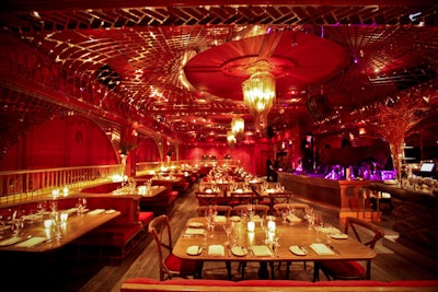 The Darby's 100-seat crimson room is adorned with tufted banquettes, booths, and a weblike metal structure on the ceiling.