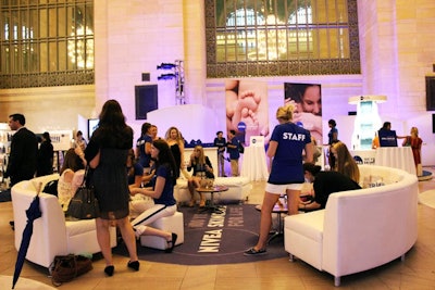 In addition to branded circular rugs in blue and white, a lounge space is furnished with white sofas arranged in a circle.