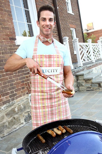 A hunky grill master in a plaid apron served hot dogs throughout the party.