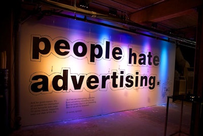 Near the entrance, markers hung from the ceiling in front of a large poster that said 'people hate advertising.'