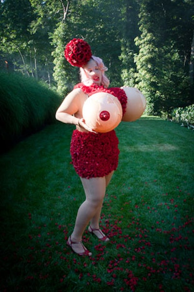 The center's founder, Robert Wilson, greeted guests at the entrance, a narrow mirrored stairway flanked by hedges, standing beside an installation called 'Milk the Cow.' The performer, who wore oversize rubber breasts and smeared lipstick, was surrounded by a buckets of cherries and cream.