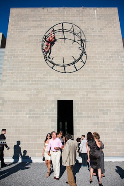 In the main cocktail area, an installation on the facade of the Knee building consisted of a red-paint-smeared performer climbing around a a circular frame, mimicking the motions of the clock.