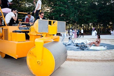 On the west terrace, musicians from the band People Get Ready–performers who later served as entertainment during dinner–sat atop a steamroller created by artist Peter Coffin. The large mechanical–and musical–machine drove in circles, traveling around Charlie Le Mindu's 'Glitterpool,' which featured nearly naked girls bathing in oil and silver glitter.