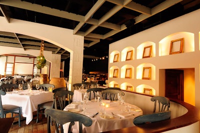 The dining room is filled with natural light. The private dining room is separated by glass doors at the back of the space.