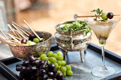 For a wedding industry association event at Malibu’s Church Estate and Vineyards, Good Gracious!’s mixologist Dan Smith looked to incorporate the reception’s surroundings (grapes on the vine and fields of fresh herbs) into a signature cocktail. He created the Vineyard Martini, which included green grapes, white pepper, oregano-infused simple syrup, vodka, and sparking lemon soda, and was garnished with a grape skewer and oregano sprig.