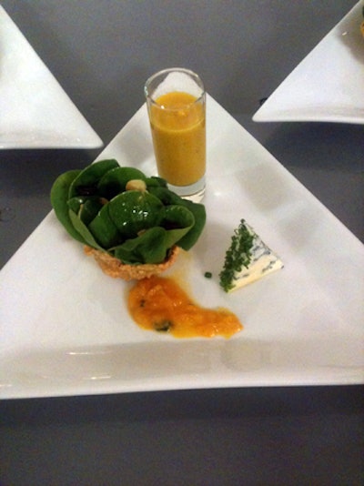 For an upcoming event, Food Evolution created a trio of autumn dishes. The menu includes a baby spinach salad with dried cranberries, white balsamic vinaigrette, and toasted almonds served from a potato-lattice basket; butternut squash and Fiji apple soup served from a shot glass; and a wedge of blue cheese.