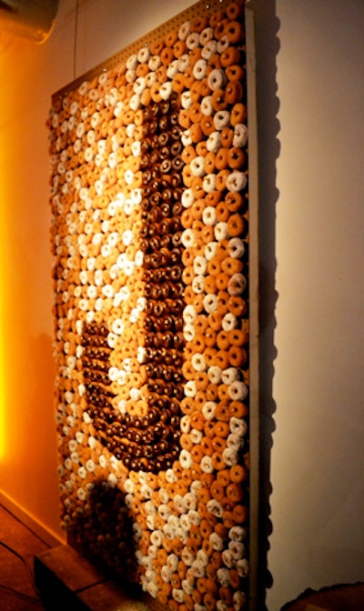 Evoke designed a doughnut wall that Design Cuisine executed for a client in April and will continue to offer the concept this fall. The wall was constructed out of pegboard, with 1,200 wooden golf tees showcasing the chocolate-glazed chocolate doughnuts (forming a “J” for the guest of honor’s name) and the outlining cinnamon sugar and powdered white donuts. In coming months, a server with a step stool will be on hand to pull doughnuts off the wall for guests, who can carry the take-home treats away in brown paper bags with to-go cups of hot apple cider.