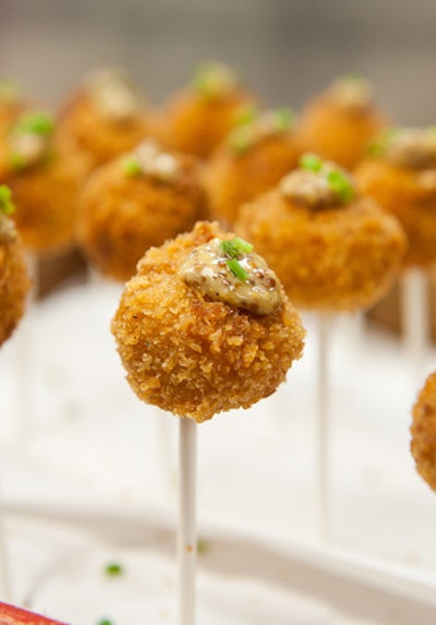 Spilled Milk Catering is serving a savory take on the lollipop this fall with its five-cheese mac-and-cheese lollipops. Composed of elbow macaroni and Gruyère, pecorino, Parmesan, white cheddar, and fontina cheeses, the hors d’oeuvre is coated in panko and served alongside a tangy mustard sauce.