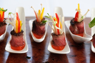 The Food Dudes wrap slices of triple-seared beef around pickled enoki mushrooms, bell peppers, and pea shoots. The colourful hors d'oeuvre is served on top of a red pepper chimichurri sauce.