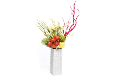 “Vessels encrusted with sequins and mirrors give way to red coral branches, tucks, orchid blossoms, amaryllis blooms, thistle, and protea.” Floral accents designed by Whitfield’s partners at Revel Decor