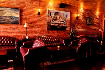 Brick walls and tufted couches fill the space.