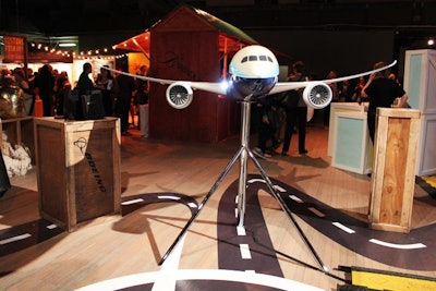 Boeing's display to highlight its Dreamliner looked more like an art installation, showcasing a scaled-down version of the futuristic aircraft amid crates and a curving flight path. The area also had an interactive touch-screen display designed to give attendees a virtual experience.
