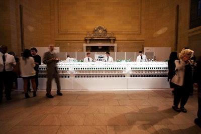 In keeping with the event’s blue, green, and white color scheme, the event's minimalist white bar featured a facade marked by three rows of the Eau de Lacoste L.12.12 fragrance bottles.