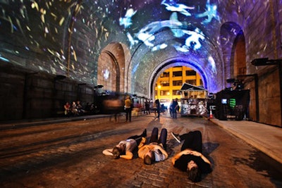At night, the Leo Kuelbs Collection's piece, known as 'Immersive Surfaces,' projected video onto the Manhattan Bridge Anchorage and archway. The installation, along with Minus Space Gallery's 'Tedd Stamm' exhibition, won the Best Festival Exhibition prize.