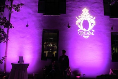 Projections of the Qream logo added to the pink uplighting in the courtyard of the Decatur House.