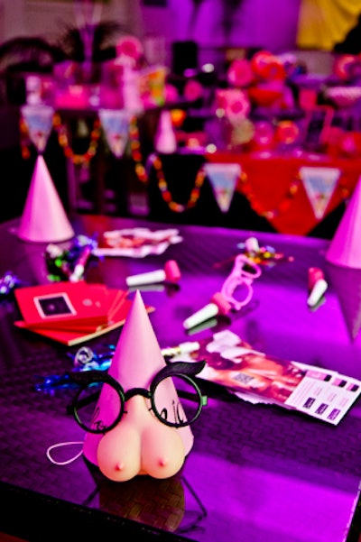 Party hats, horns, and breast-themed favours decorated the tables.