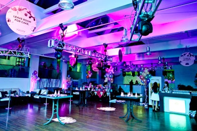 Andrew Richard Designs was lit in pink and purple lights. The space was decorated with balloons and playful signs hung from the ceiling, with phrases like 'leave room for cake.'
