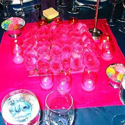 Square centerpieces of bright pink roses and pink votive candleholders were flanked by silver bowls of colorful rock candy.