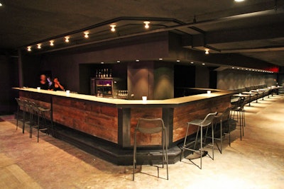 The built-in bar wraps around, connecting the lounge and stage areas. Leather banquettes line the lounge area.