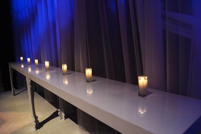 Wall-to-wall white carpeting, long white console tables, and candles created a sleek, simple setting.