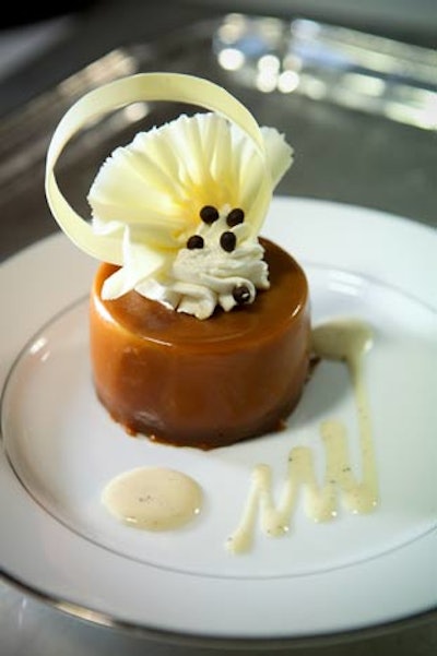 Waiters served flourless chocolate cake layered with caramel mousse and diced poached pears with a vanilla sauce for dessert.