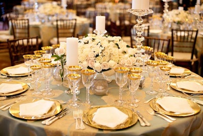Rafanelli chose a robin’s egg blue, satin table covering embroidered in gold thread in a large, gardenia-like floral design for the dinner tabletop mix of rounds for ten and the secretary’s head table for 20.