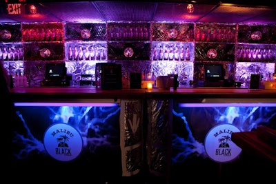 As a fun way to decorate the bar on the main floor, Extra! Extra! covered the surface with tin foil and displayed Malibu Black bottles beside plasma globes.