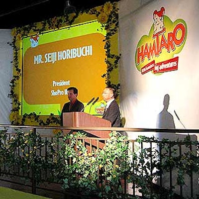 A sales presentation was given on a stage decorated with sunflowers and vines.