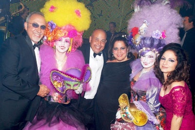 Emilio and Gloria Estefan posed with guests and models in masquerade costumes at the Diamond Ball.
