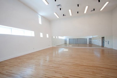 The dance studio, primarily used for rehearsals, features high ceilings and mirrors.