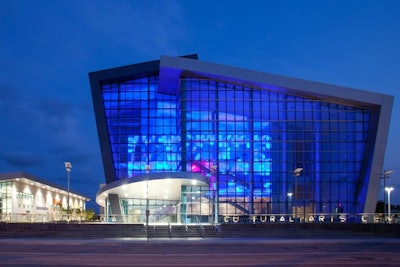 The center's glass facade is wrapped with folded planes, creating its unusual architecture.