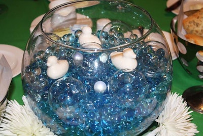 Special Event Floral filled fish bowls with jumbo white and smaller blue water pearls, then added battery-operated lights. The Peabody Orlando's duck soap appeared to float on top of each centerpiece.
