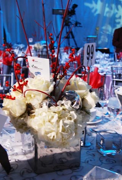 Decor & More created the centrepieces with white hydrangeas and roses, silver spheres, dogwood, and red berries.
