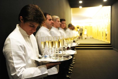 A phalanx of waiters offered drinks to guests as they made their way down the long black carpeted hallway from arrivals into the cocktail lounge.