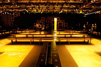 Signaling the end of cocktails, models pulled open a series of doors and waved guests into the 10,000-square-foot fashion show venue. The runway was designed with a Greek motif and maze surrounded by 16-foot-tall walls. Since the collaboration is about making Versace accessible, it was important for the seating configuration to be democratic and give the majority of guests a front-row view, rather than the typical multitiered bleacher setup.
