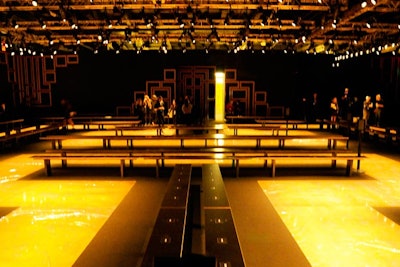 Signaling the end of cocktails, models pulled open a series of doors and waved guests into the 10,000-square-foot fashion show venue. The runway was designed with a Greek motif and maze surrounded by 16-foot-tall walls. Since the collaboration is about making Versace accessible, it was important for the seating configuration to be democratic and give the majority of guests a front-row view, rather than the typical multitiered bleacher setup.