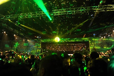 As Donatella Versace took her runway bow, she exited straight through a set of doors that opened to reveal the after-party. Measuring 12,000 square feet, the section was designed to resemble a Miami nightclub, with huge sheets of palm-print-patterned wallpaper covering the walls and disco balls hanging overhead. A custom stage was erected to accommodate performances by Nicki Minaj and Prince, while tiered, banquet-style seating was made available to all guests. The fashion designer hosted a V.I.P. section off to stage left.