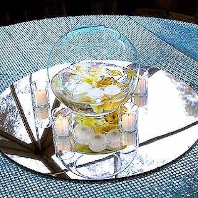 Musters & Company draped tables with silver and blue sequined tablecloths and topped them with mirrored plates and glass bowls filled with floating tea lights.