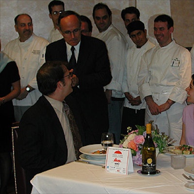 Mayor Rudy Giuliani goofily played waiter for guests assembled at a table next to the podium.