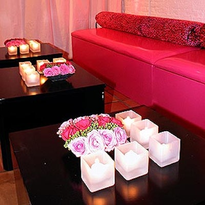 A wall of magenta couches were adorned with animal-print pillows and tables were topped with square floral centerpieces surrounded by square votive candle holders. (Photo by Stillman Jefferson Thomas Digital Photography)