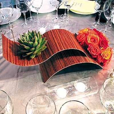 The tables' masculine looking centerpieces used metal and wood veneer sculptures with bouquets of red, yellow and orange roses and a variety of unusual plants that looked like a cross between an artichoke and a cactus.