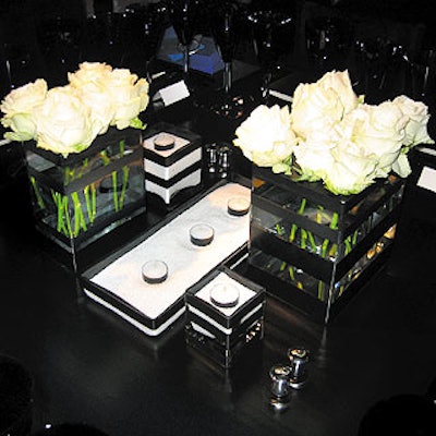 Black tables were decorated with squat, square vases with black horizontal stripes that held white roses and tea lights.