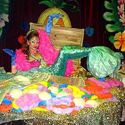 At the New York Restoration Project's Hulaween benefit at the Marriott Marquis, an actress dressed as a mermaid from Hollywood Pop Gallery posed atop a table covered with party favors.