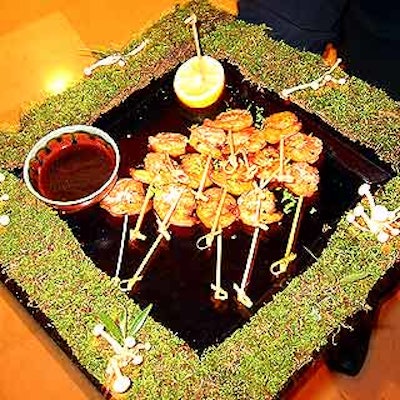 Sonnier & Castle served grilled shrimp satay with Thai basil ginger lime dipping sauce on serving trays decorated with moss and mushrooms for an enchanted forest look.