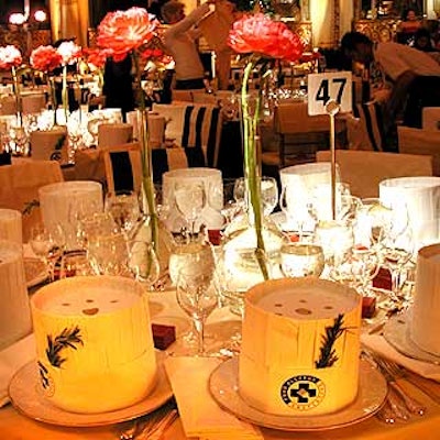 Tables were decorated with pink peonies in single-stem vases, and each place setting was topped with a white chef's hat.