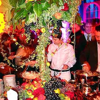 A large flower arrangement on a slender pedestal dominated the main buffet, with fruit and more flowers scattered around the table.