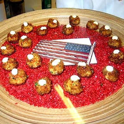 At the American Folk Art Museum's American Antiques Show benefit preview, The Catering Company served bite-sized crab cakes with citrus mayo on wooden trays decorated with all-American accents like red pebbles and flags.